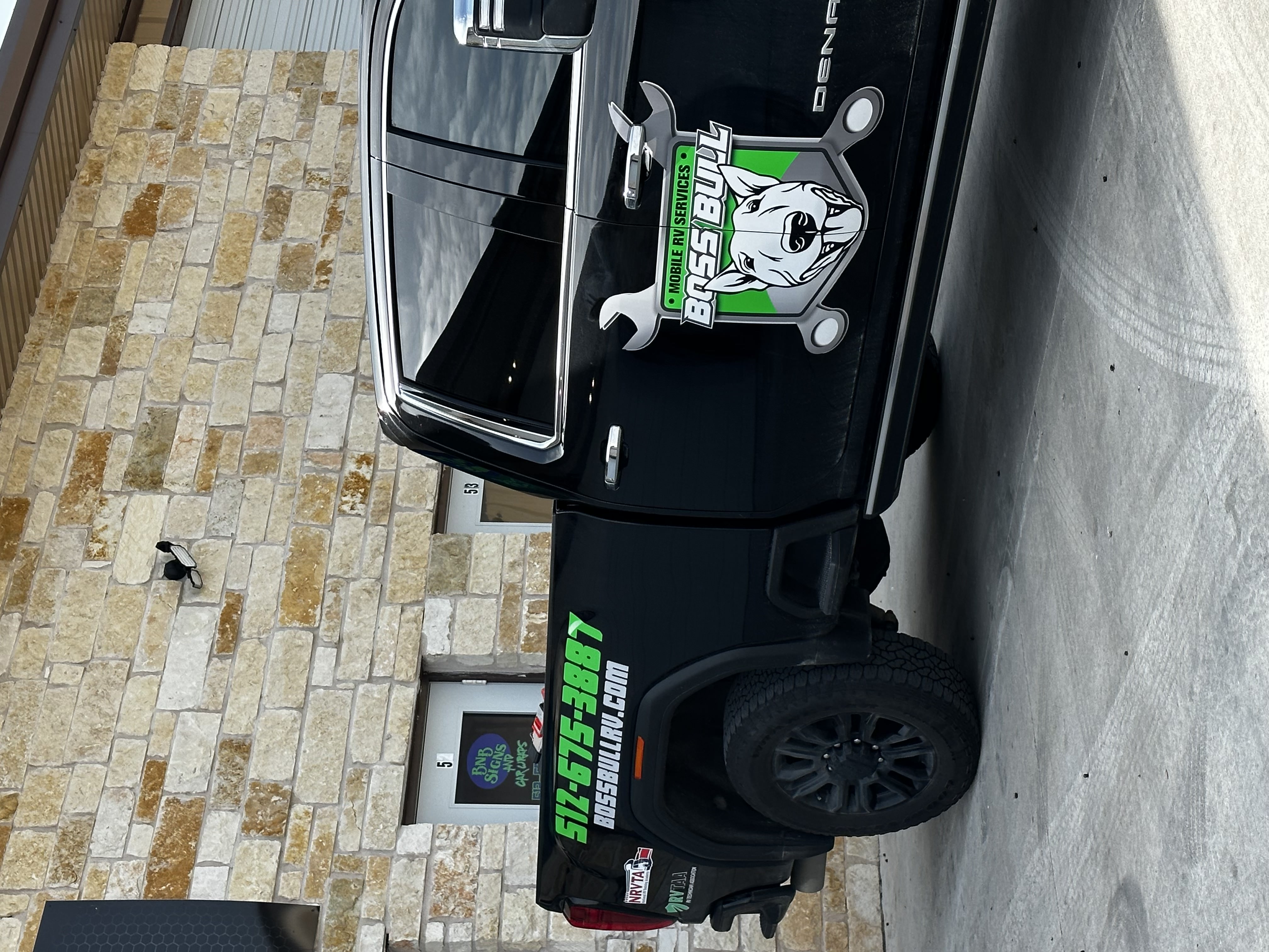 Boss Bull Mobile RV Services branded black GMC Denali truck showing the Boss Bull logo, phone number 512-675-3887, and BOSSBULLRV.COM on the truck bed