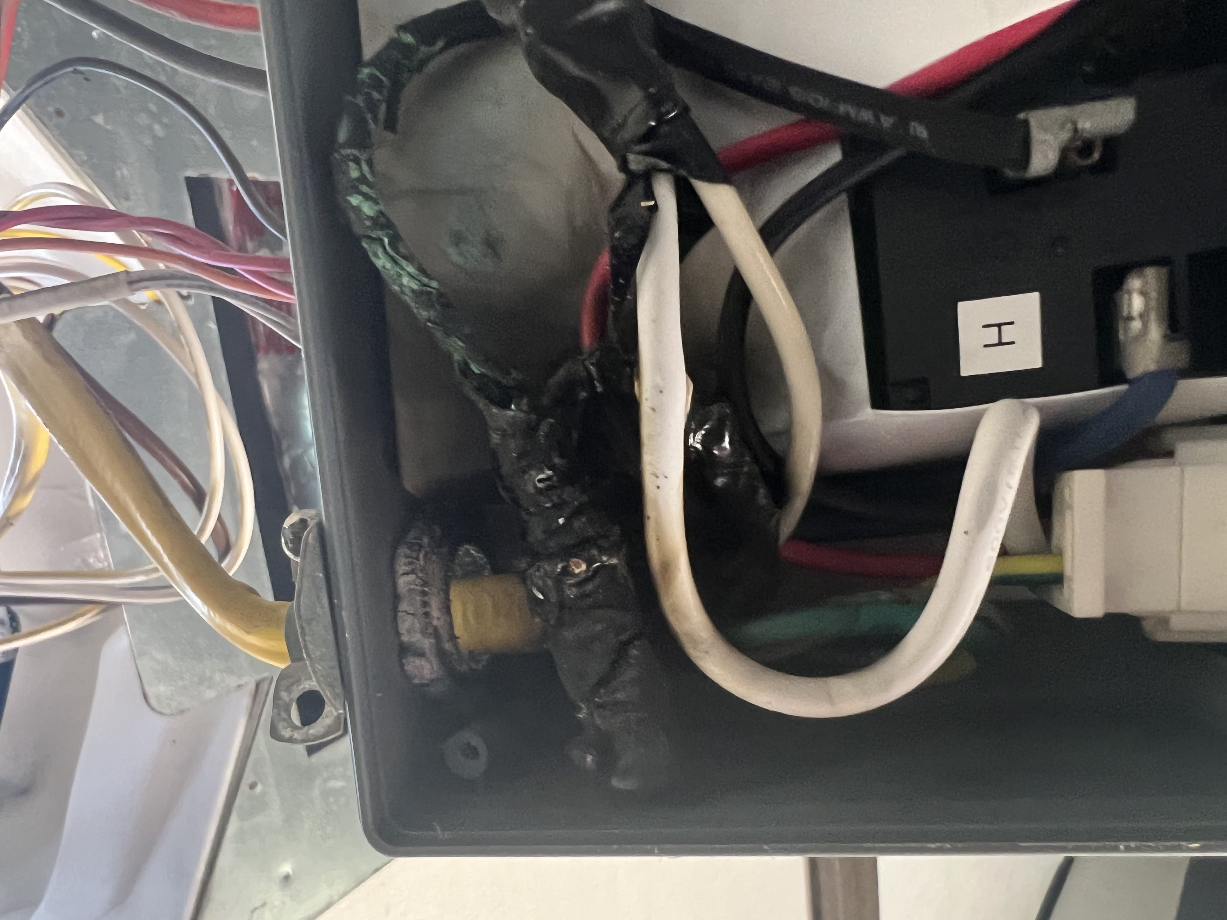 Severely burnt and melted wiring inside an RV air conditioner control box — electrical failure documented during an RV AC service call — Boss Bull Mobile RV Services