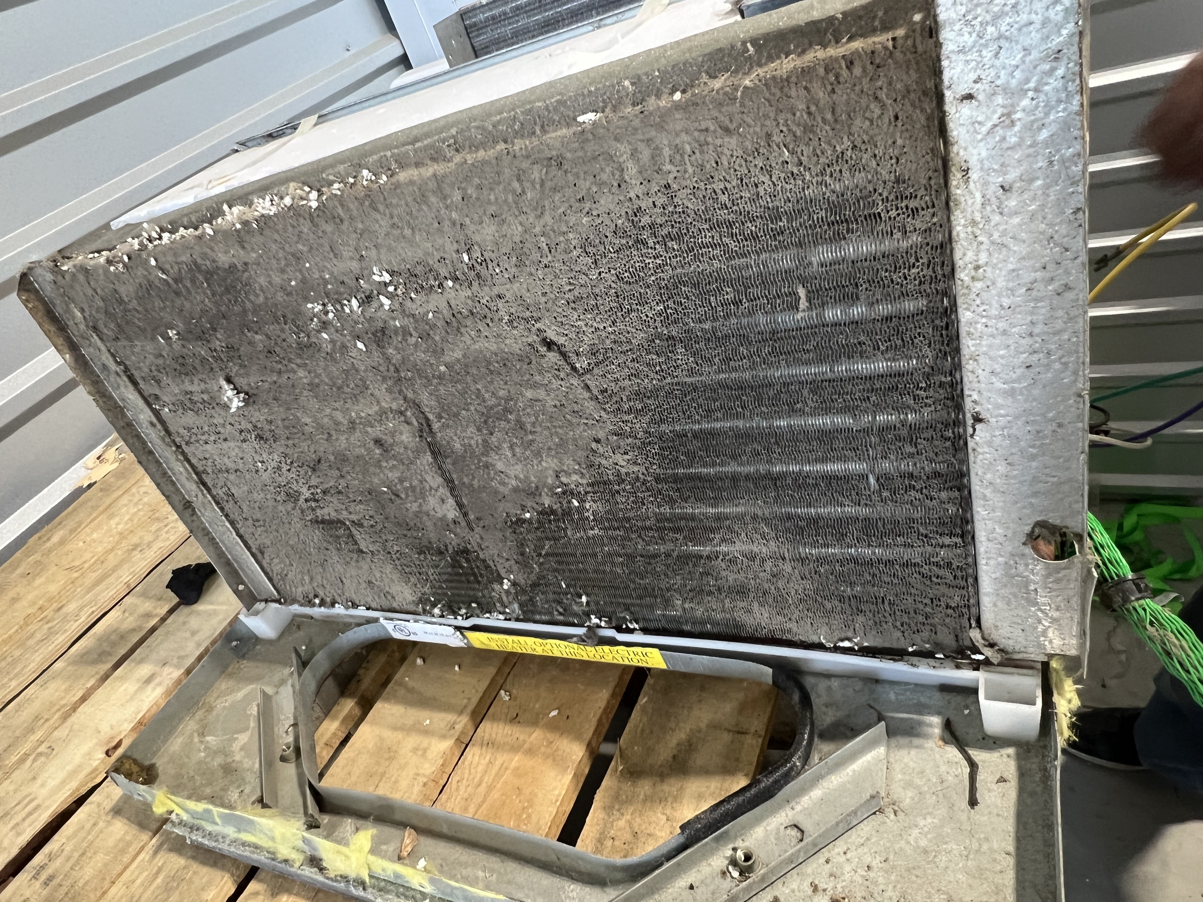 RV AC condenser panel loaded with debris — full-face view before cleaning on a Cedar Park family trailer preparing for a spring break trip