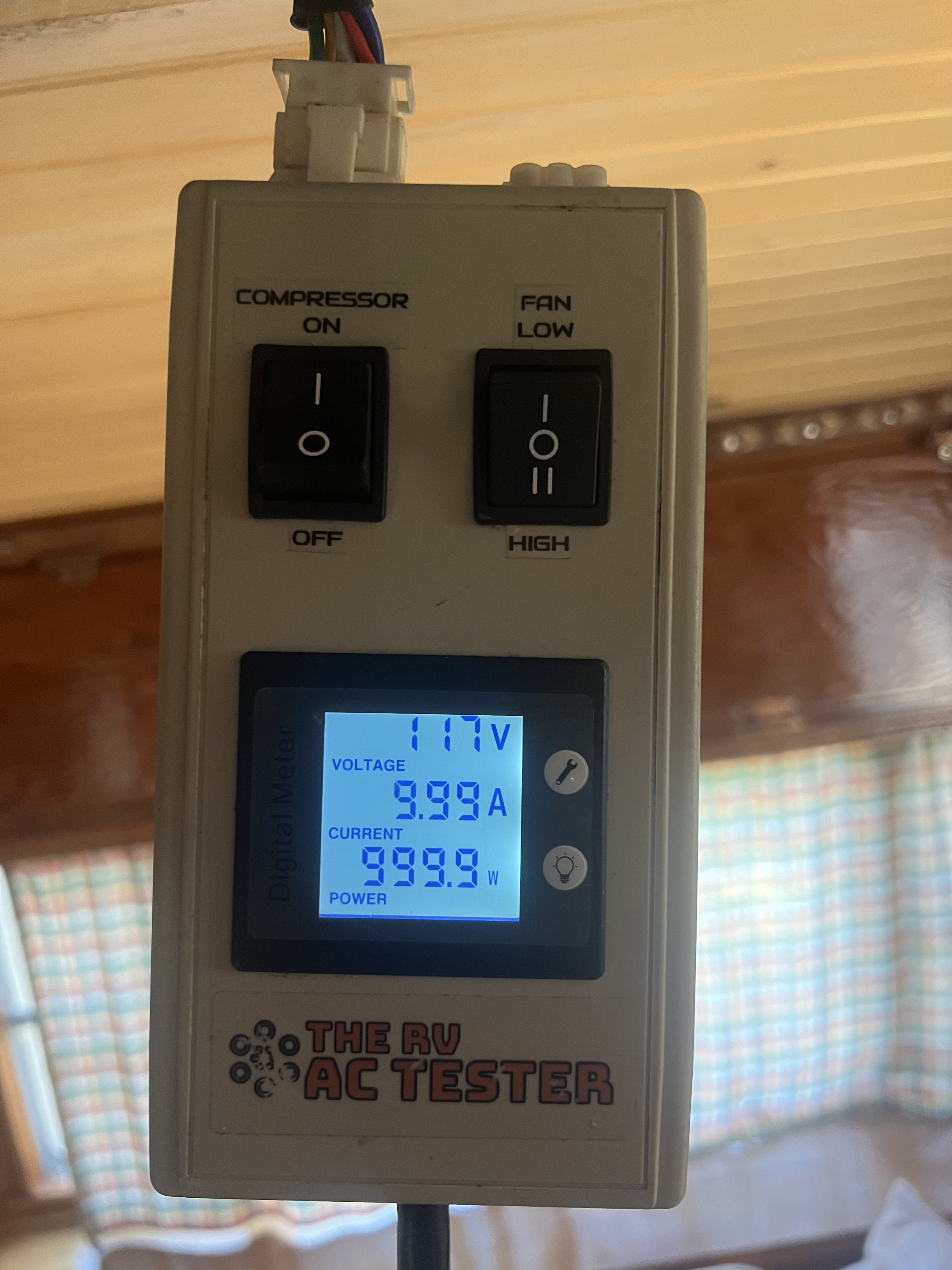 Boss Bull technician using an RV AC tester showing live voltage, amperage, and wattage readings during an air conditioner diagnostic service call in the Austin area