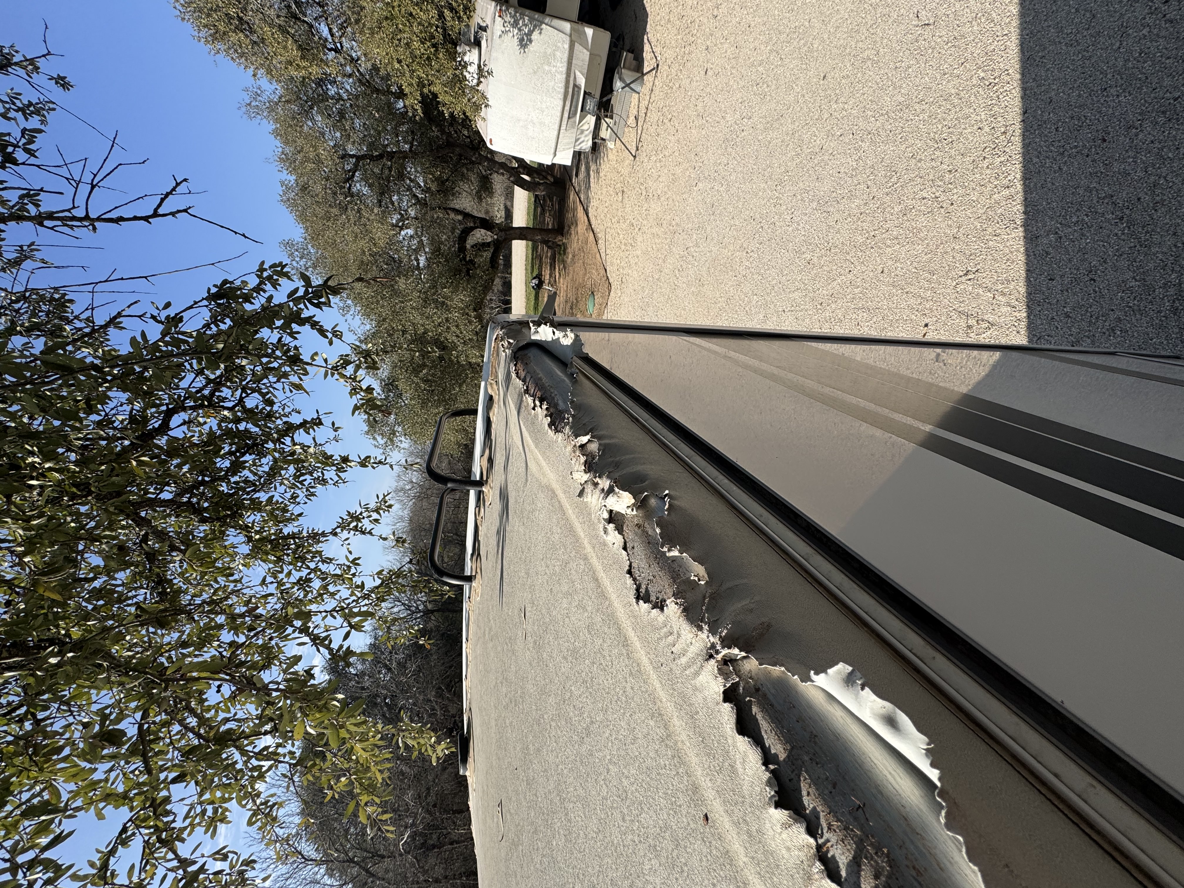 RV roof membrane failure and delamination closeup — UV-degraded membrane separation common on Liberty Hill acreage coaches stored outdoors long-term