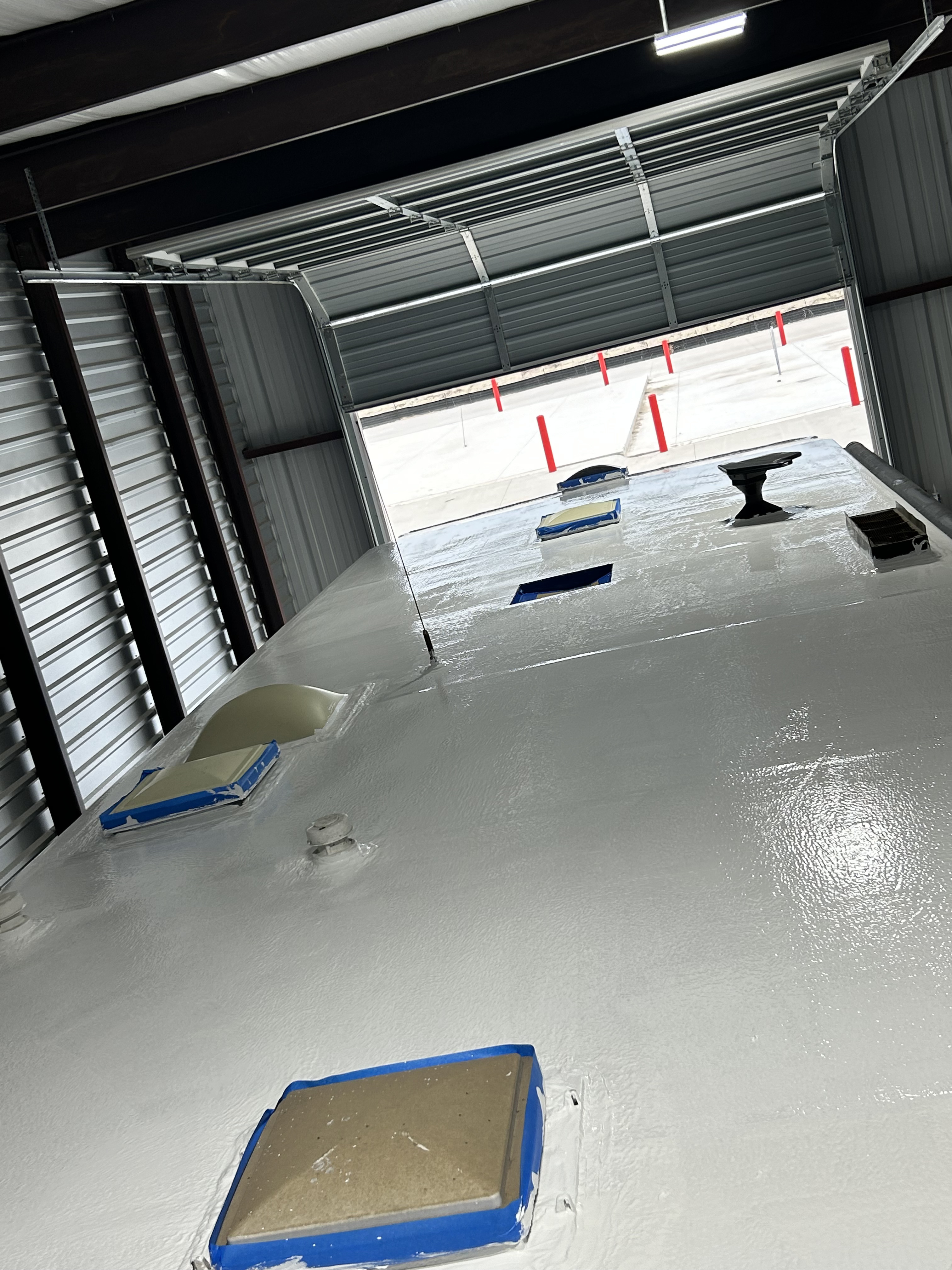 Close overhead view of a Coachmen Freelander RV roof after a complete Crazy Seal installation — white elastomeric coat fully cured with a smooth sheen, all penetrations sealed — Boss Bull Mobile RV Services