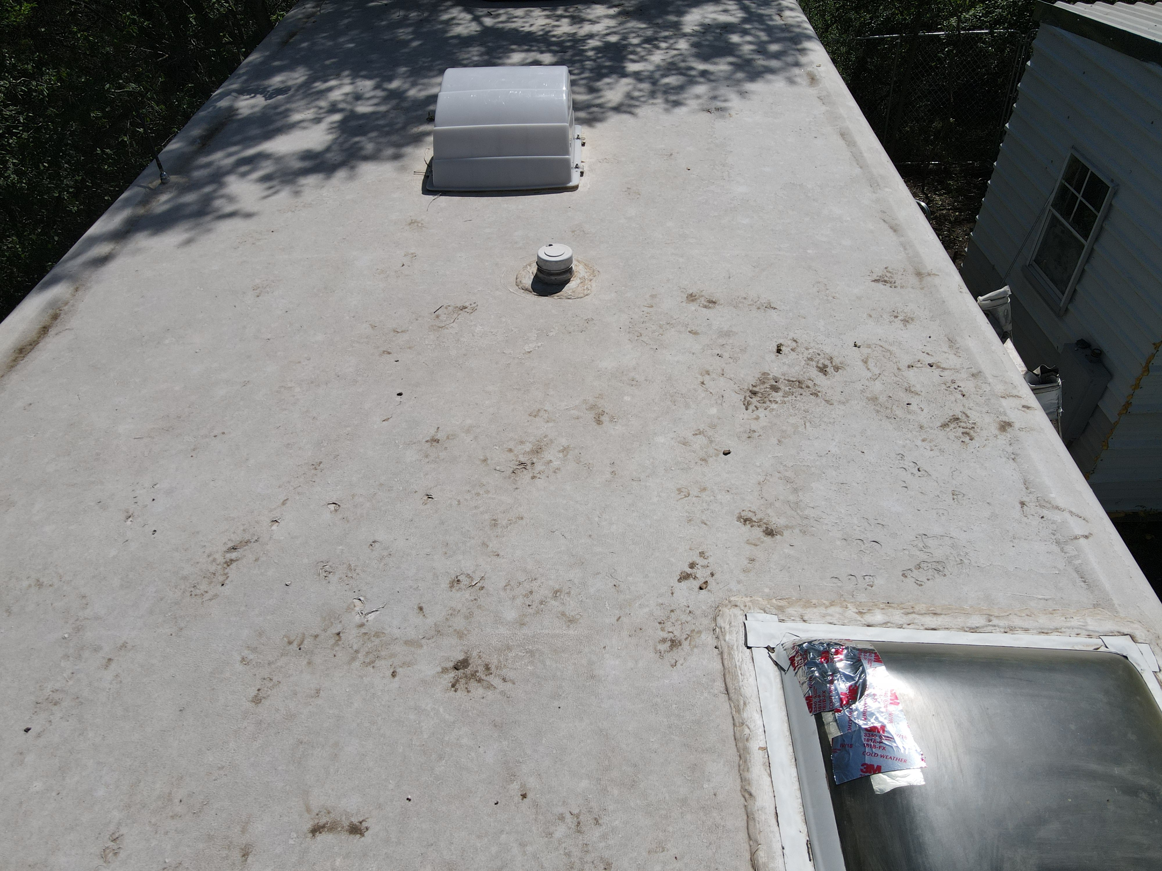 RV roof skylight dome flange showing dried, cracked, and separating lap sealant around the full perimeter of the frame — active water entry point documented before resealing — Boss Bull Mobile RV Services